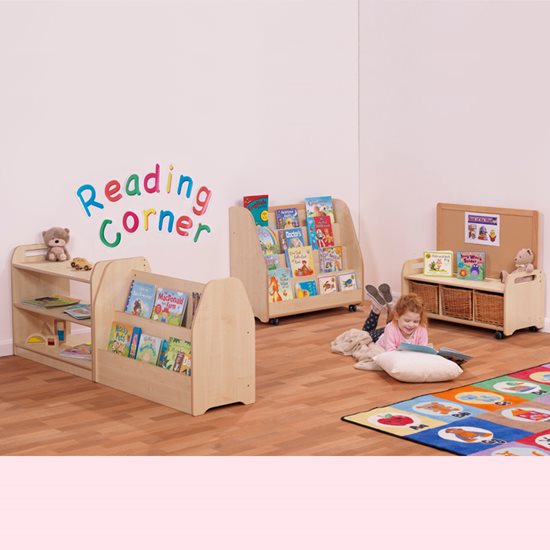 Assembled reading corner with a little girl surrounded by cushions and books.