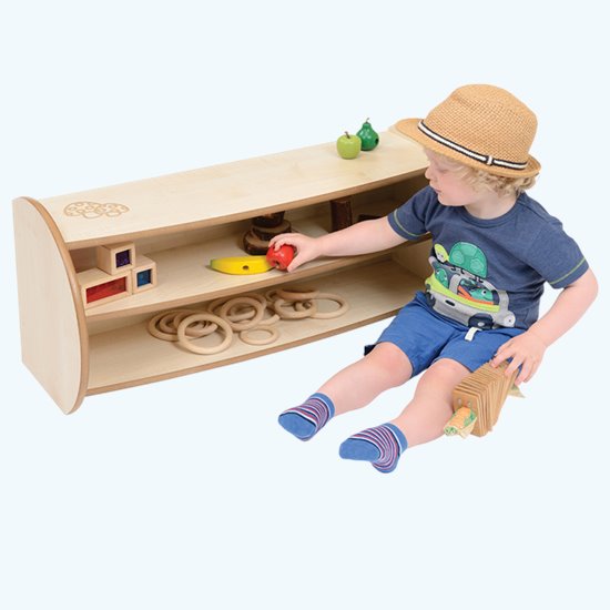 Little boy playing with natural finish shelf unit