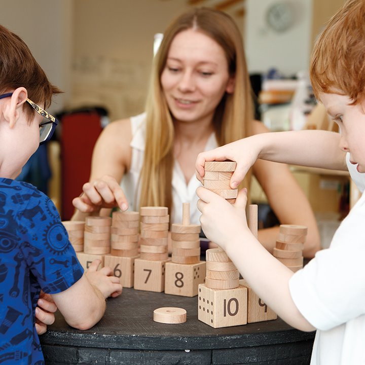 Teacher and two children playing with maths activity set
