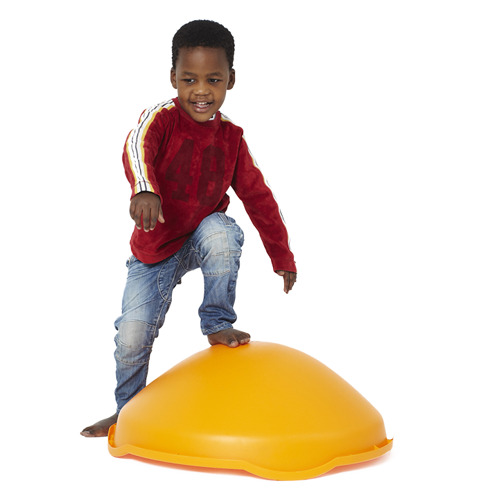 Young child standing with one foot on upside down dome