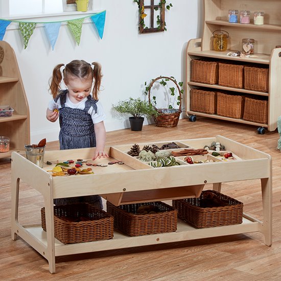 Girl sorting small objects on investigative play table