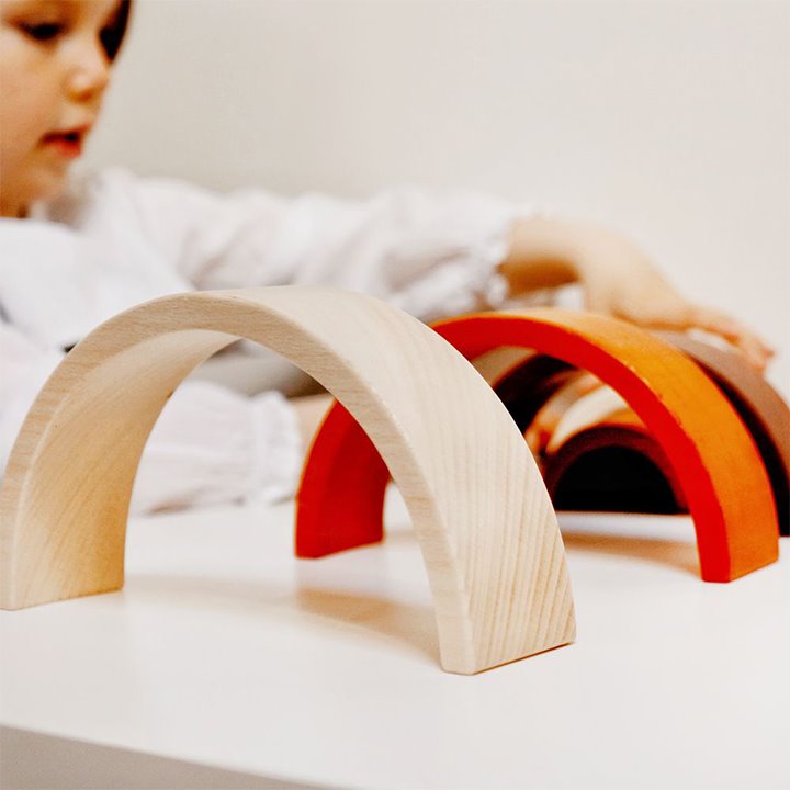 Child playing with wooden arches