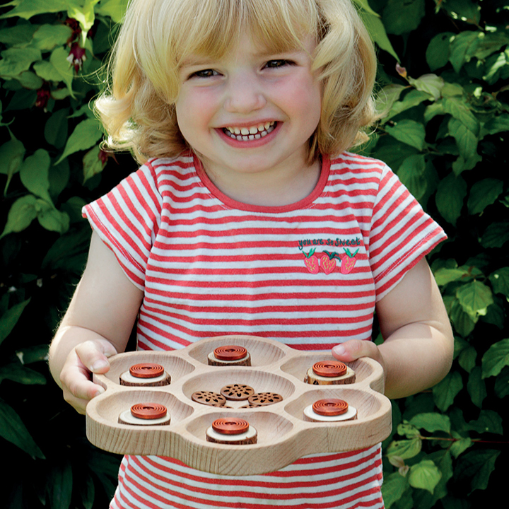 Little girl holding and smiling with flower tray