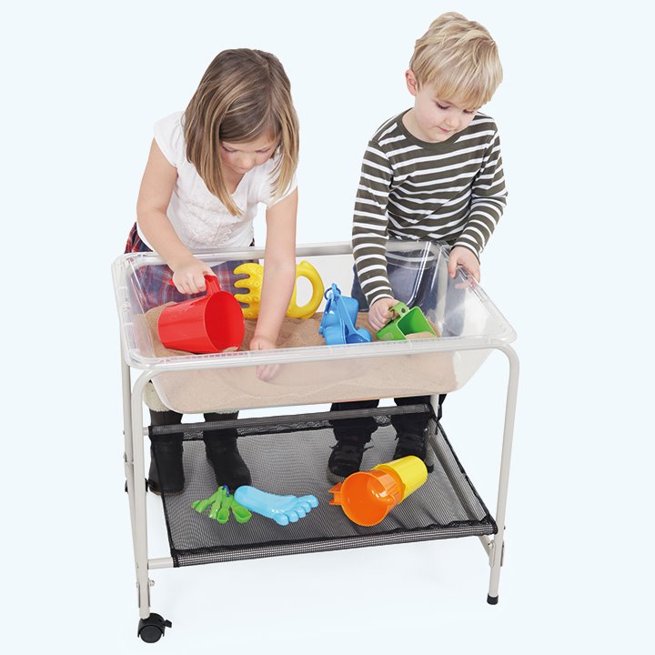 Folding stand and tray being used indoors with toys and sand