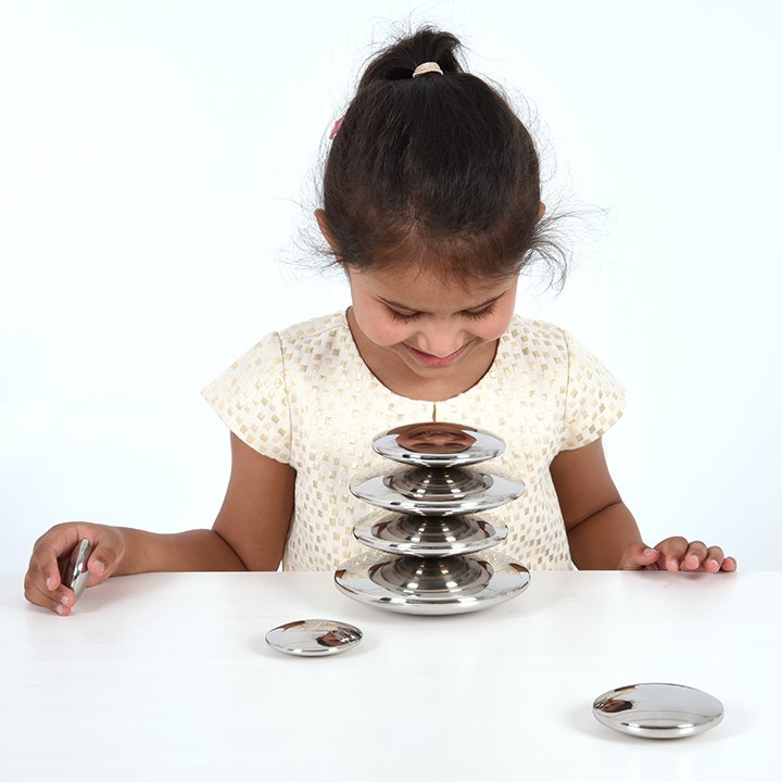 Child balancing silver button shapes