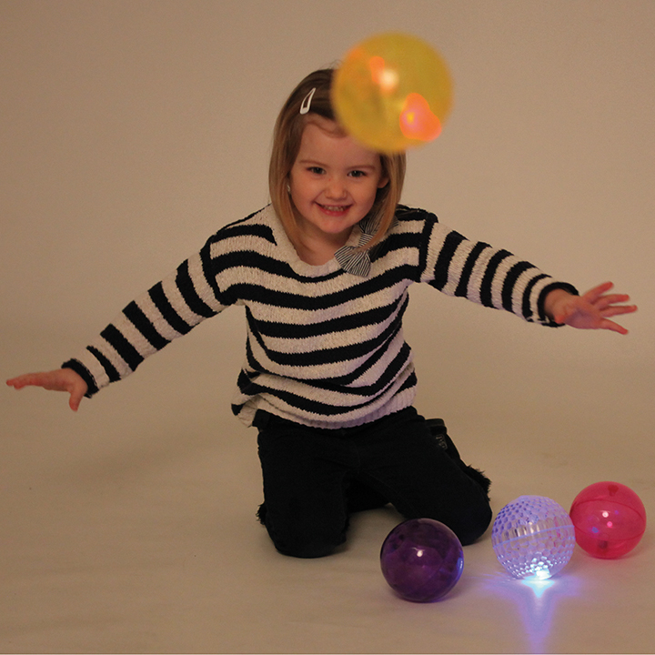 Girl playing with textured light balls