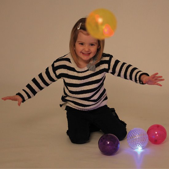Girl playing with textured light balls