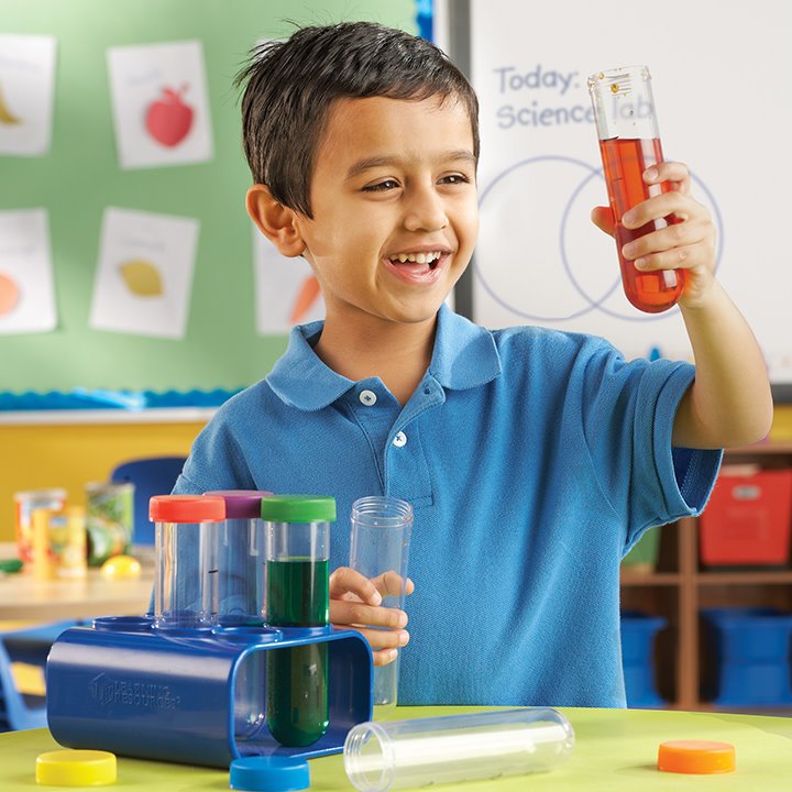 Little boy mixing colours with test tubes