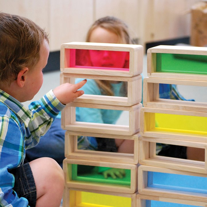 Children looking at large building bricks with coloured acrylic inserts