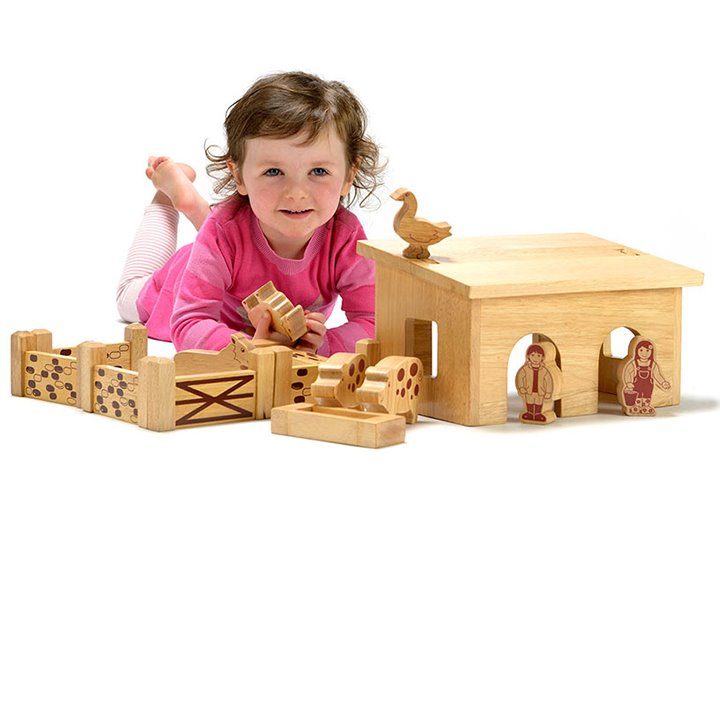 Little girl laying with small farm set