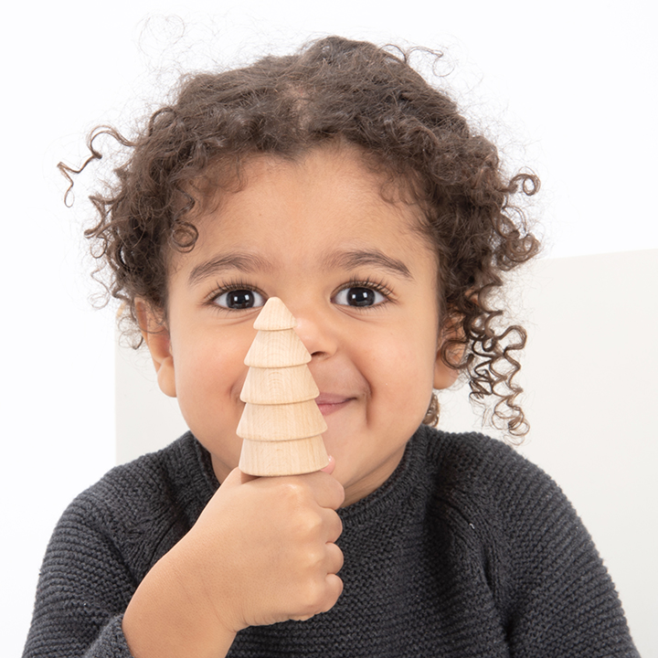 Close up of child holding tree and smiling