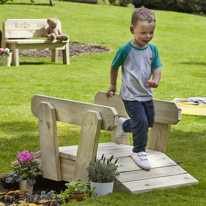 Little boy running over bridge