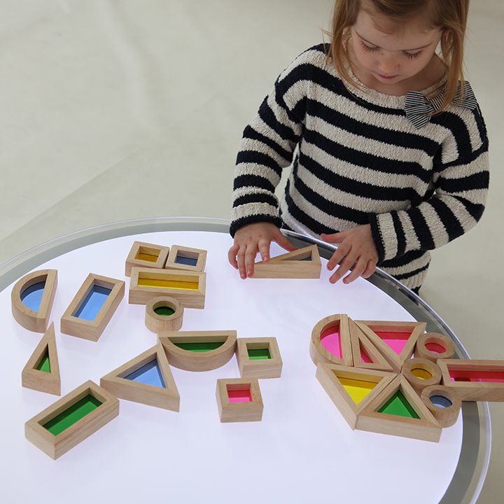 Child playing with light box and rainbow blocks