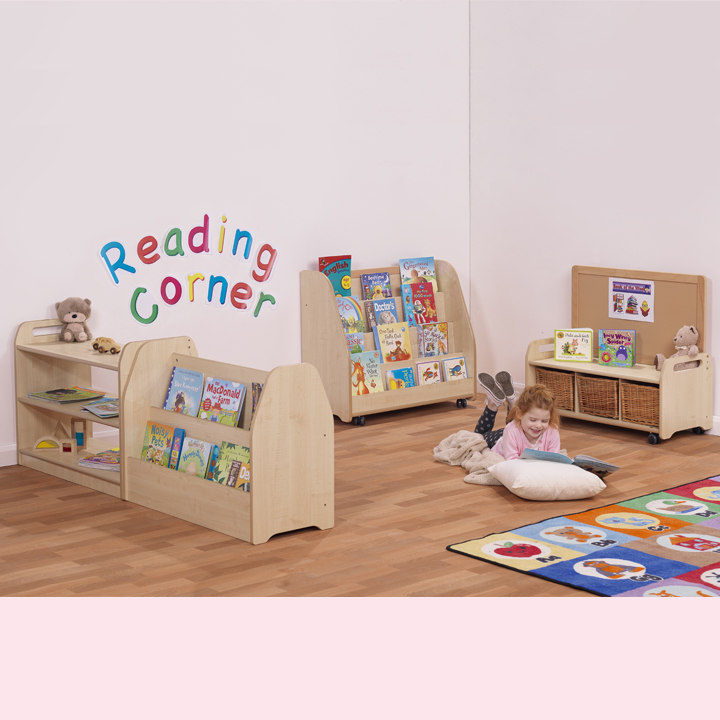 Assembled reading corner with a little girl surrounded by cushions and books.