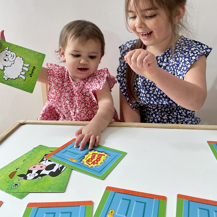 One older and one younger child playing with and using first word cards