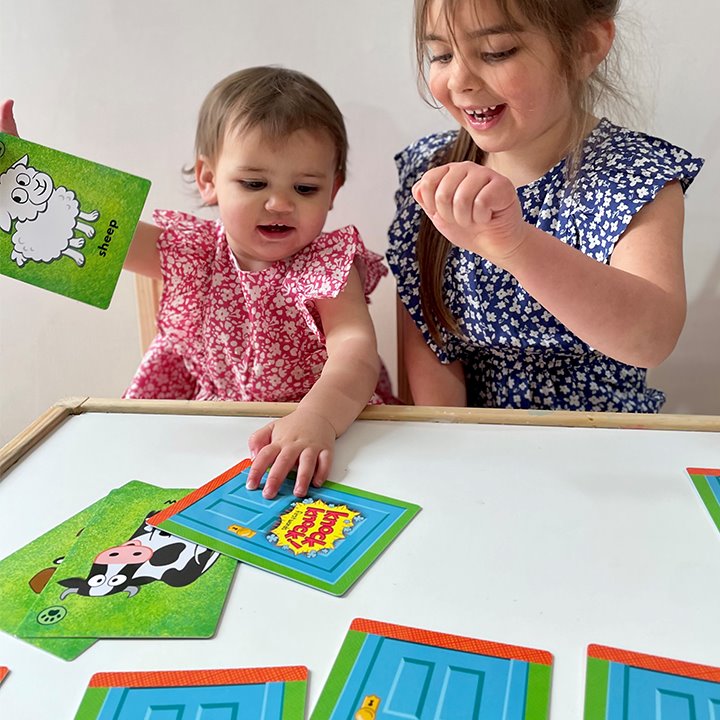 One older and one younger child playing with and using first word cards