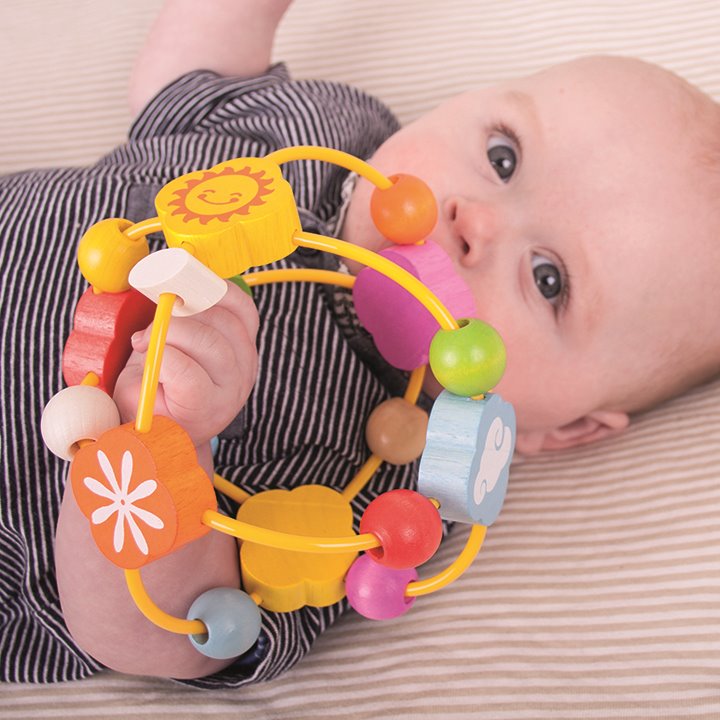 Baby with A set of super rattles - tactile play and fine motor skills.