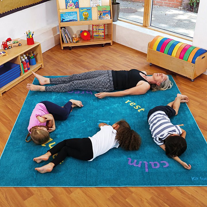 Children and teacher lying down on carpet