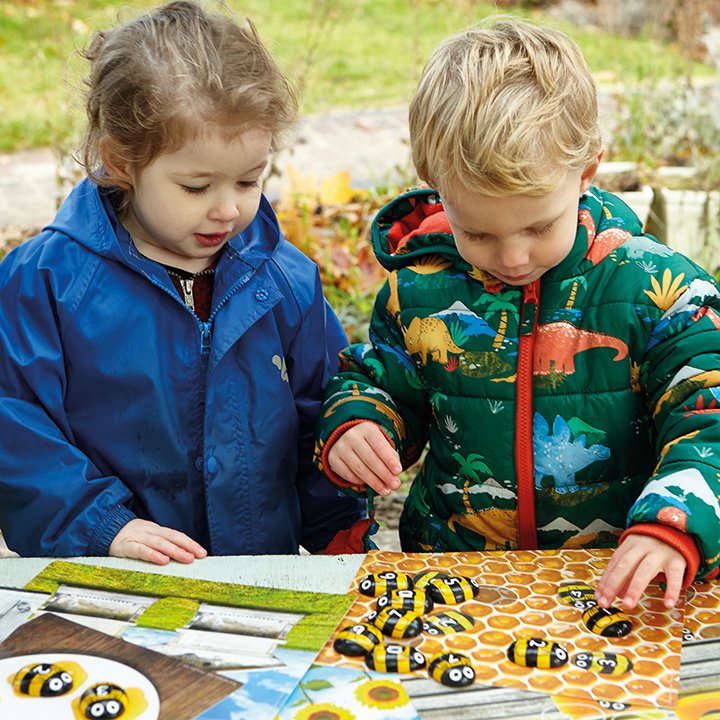 Two children using honey bee counting stones