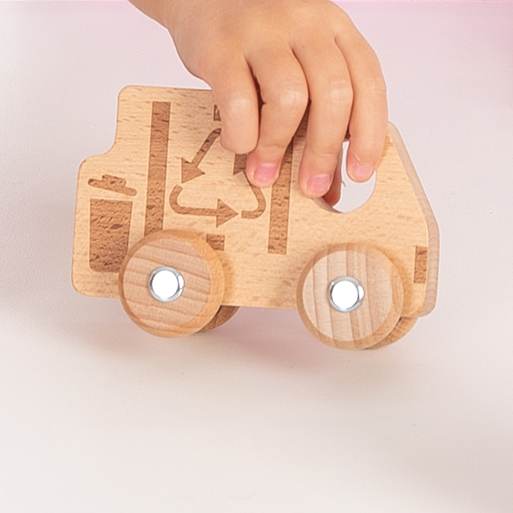 Little hand playing with wooden recycling vehicle