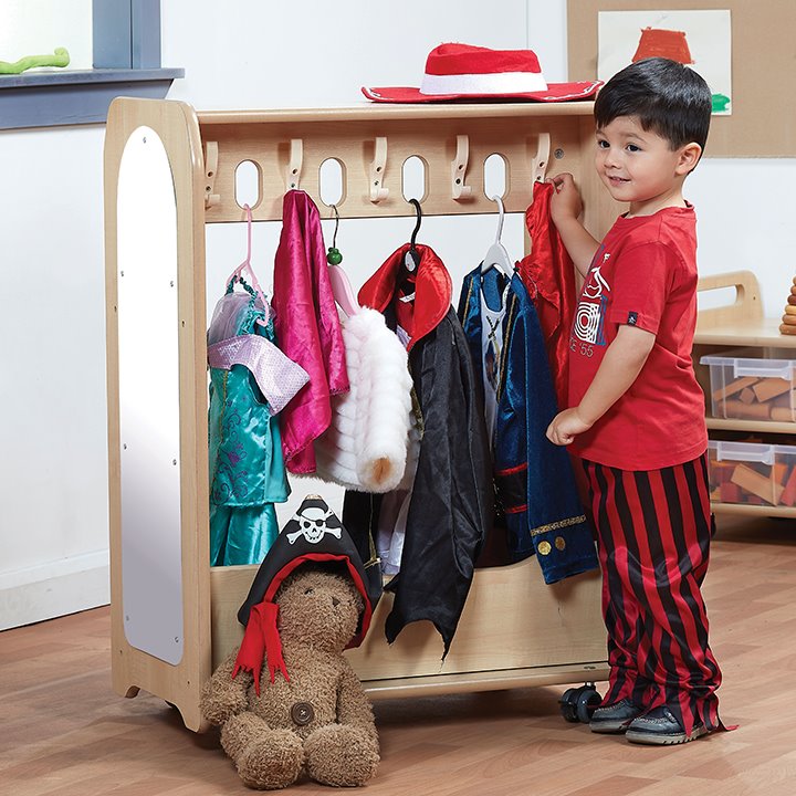 Little boy standing next to mobile dressing up unit