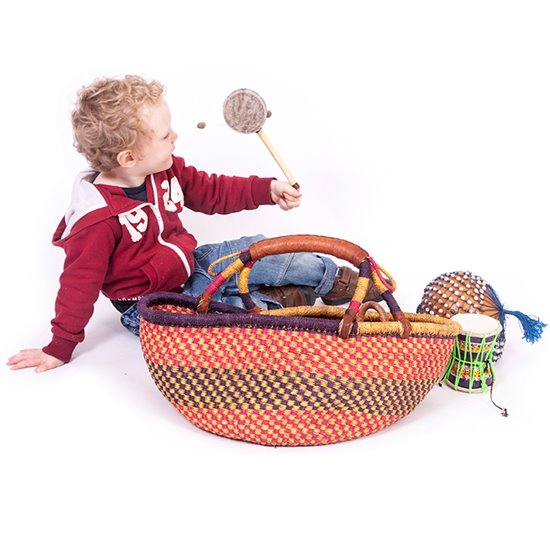 Little boy picking up instrument from basket