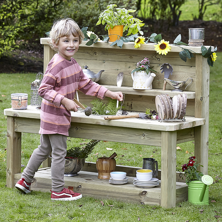 Little boy standing in front of and using multi mud station