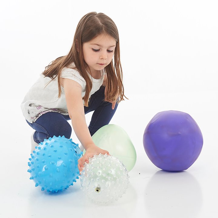 Little girl picking up oddly shaped inflatable ball