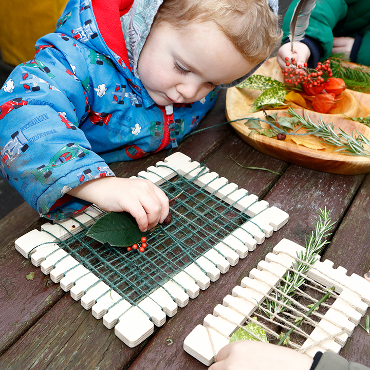 Little boy using weaving frame