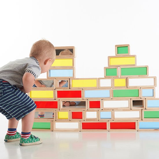 Child playing with large building bricks with coloured acrylic inserts