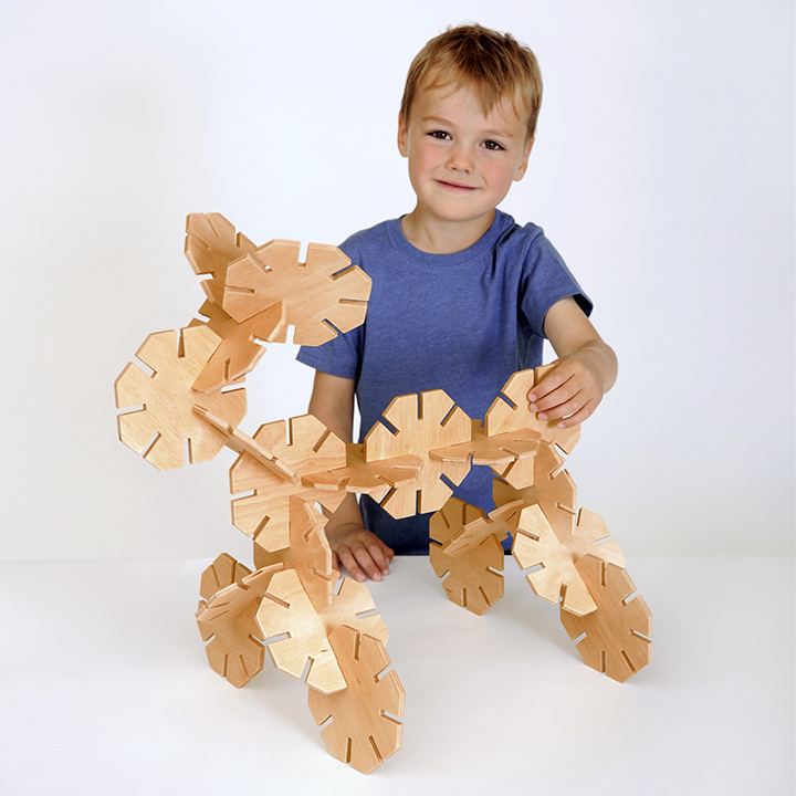 Smiling child with Chunky wooden pieces designed for small hands