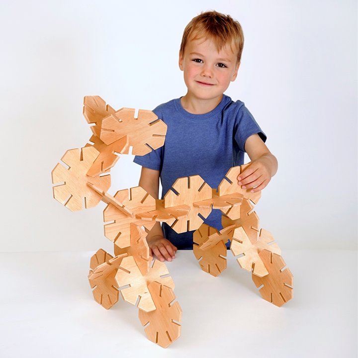 Smiling child with Chunky wooden pieces designed for small hands