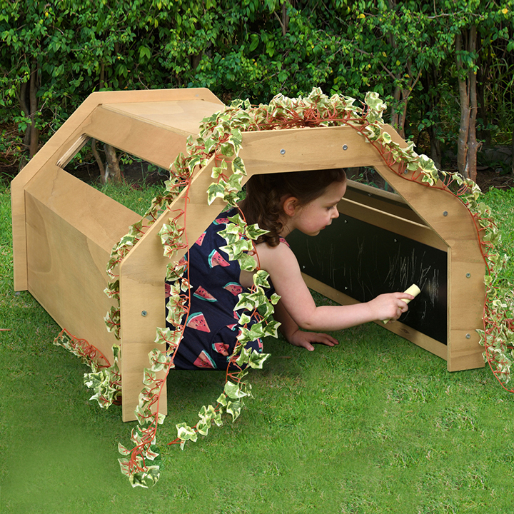 Little girl sat in activity tunnel drawing chalk on side