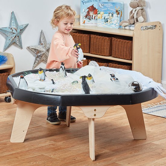 Black plastic tray on sturdy wooden legs with child playing