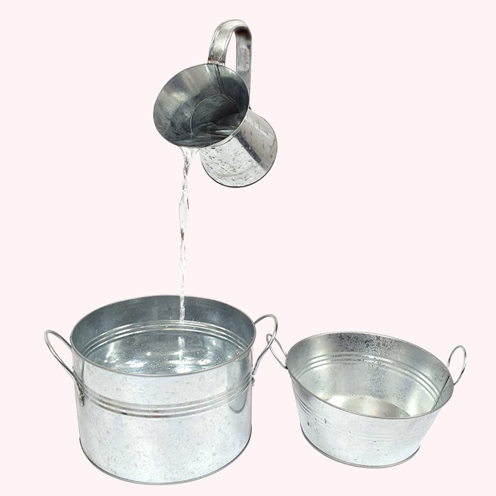 Pouring water from one jug to a metal pot