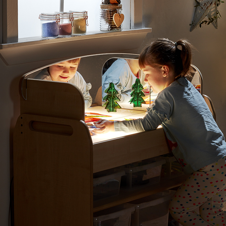 Little boy playing with toys on the light box trolley