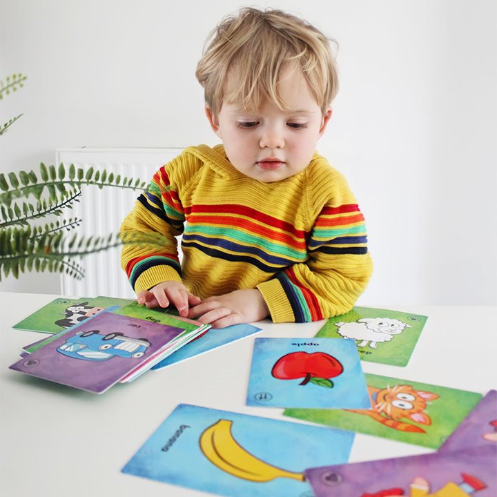 Little boy reading first word cards