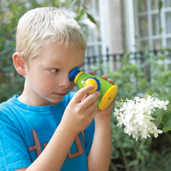 Working microscope boy looking at flower