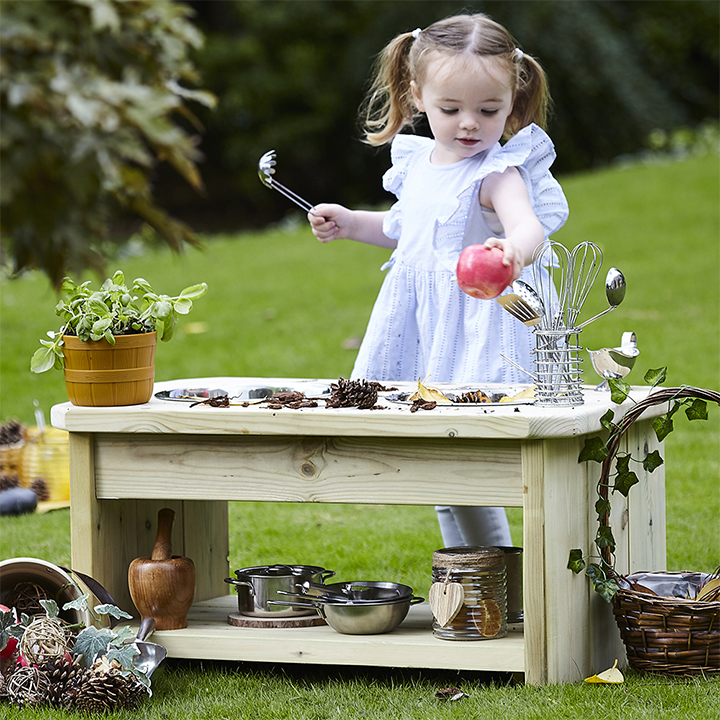 Child in garden with play kitchen